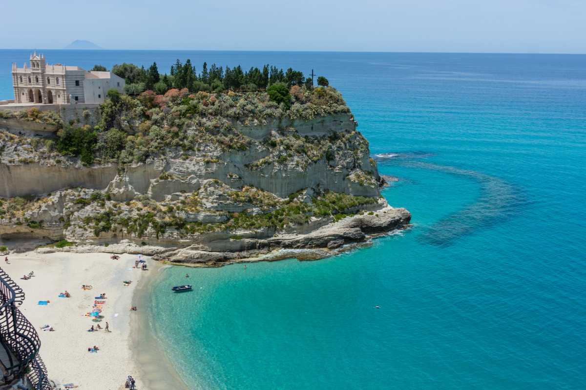 Spiaggia delle Tre Sorelle in Calabria, con tre arenili e acque cristalline, immersa nella natura.